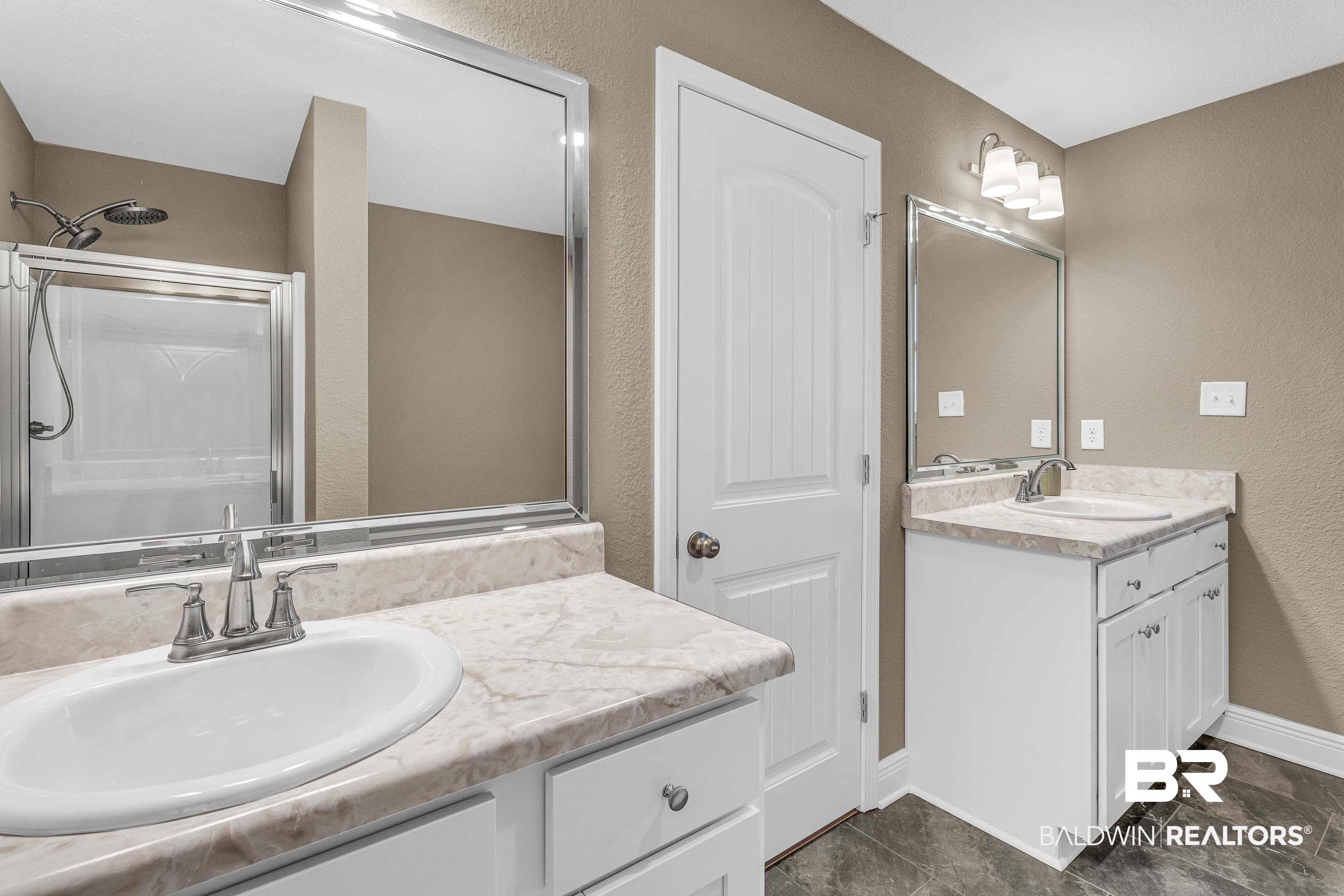 9206 Greenleaf Drive Daphne, AL 36527 - Photo 17 of 32 Bathroom with a textured wall, a stall shower, and two vanities