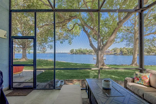 a view of a patio with couches plants and large trees