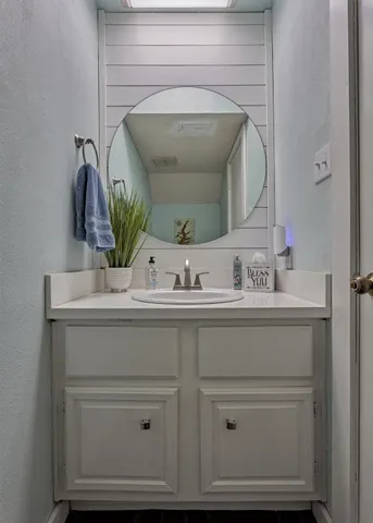 a bathroom with a sink vanity and mirror