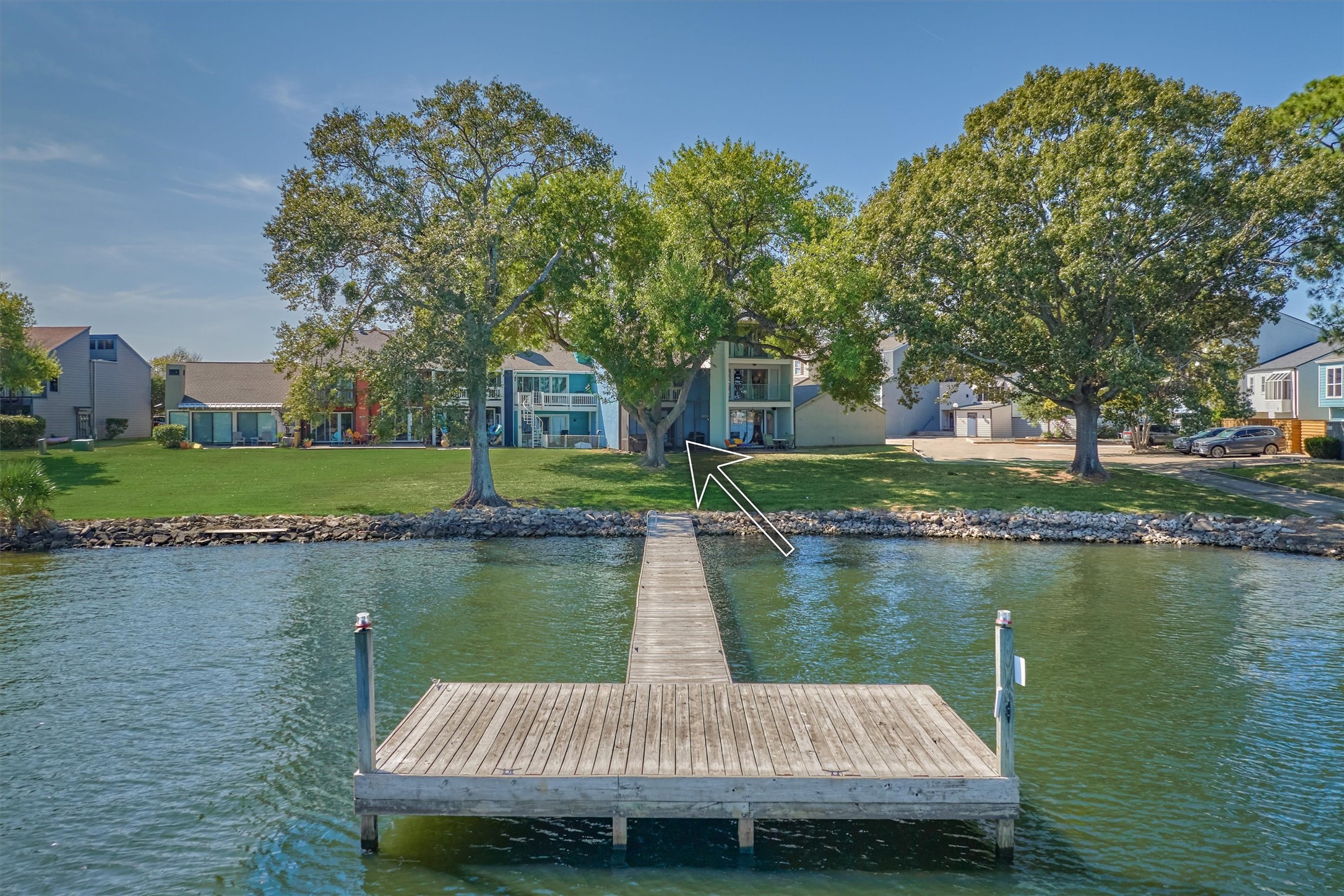 1428 Bowsprit Point Willis, TX 77318 - Photo 5 of 47 a wooden bench sitting in middle of a lake next to a yard