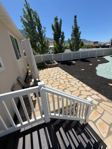 118 Tram Rock Rd. Lake Point, UT 84074 - Photo 27 of 34 Paver patio area featuring a stone planter, decorative landscaping, and a fence