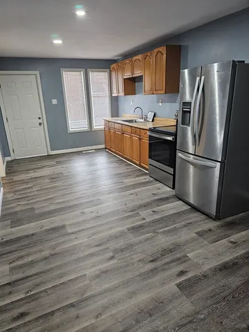 a kitchen with kitchen island wooden floors and stainless steel appliances