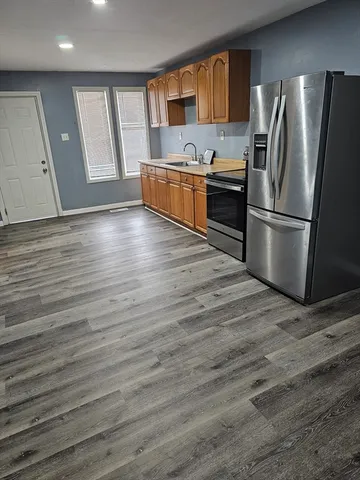 a kitchen with stainless steel appliances granite countertop a refrigerator and a stove