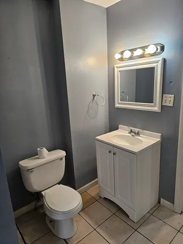a bathroom with a toilet sink vanity and mirror