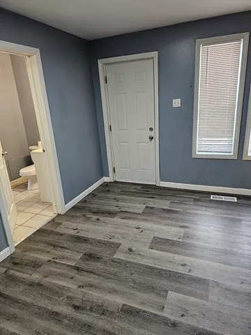a view of empty room with window and wooden floor