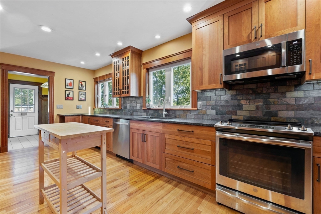 153 Ashcroft Road Medford, MA 02155 - Photo 4 of 39 a kitchen with stainless steel appliances wooden cabinets granite counter tops a stove a sink and a microwave