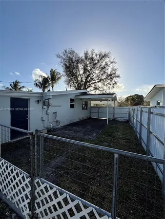 a view of a house with backyard and trees