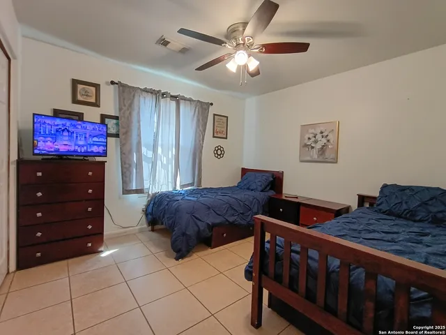 a bedroom with a bed and a ceiling fan