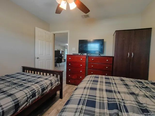 a bedroom with a bed and a flat tv screen on dresser