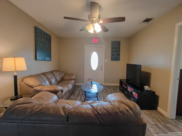 a living room with furniture a lamp and a flat screen tv
