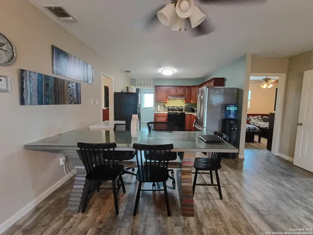 a view of a dining room with furniture a chandelier and wooden floor