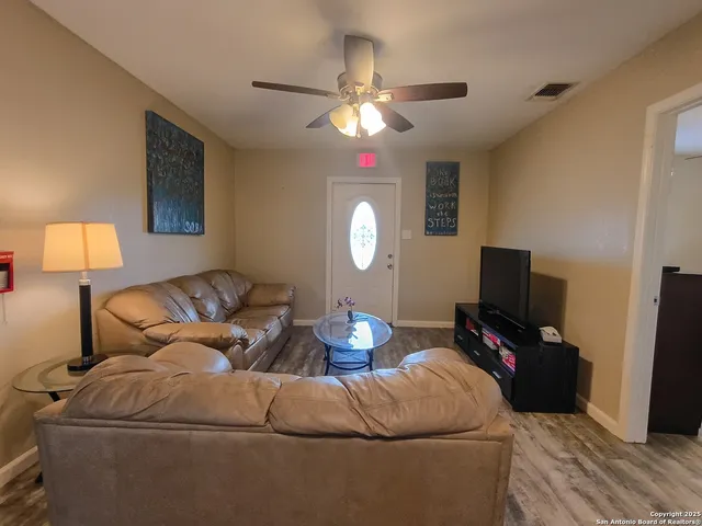 a living room with furniture a lamp and a flat screen tv