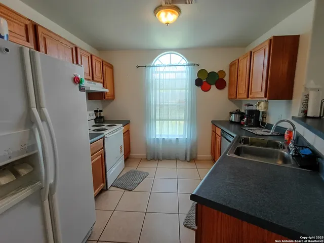 a kitchen with stainless steel appliances granite countertop a refrigerator a stove and a sink