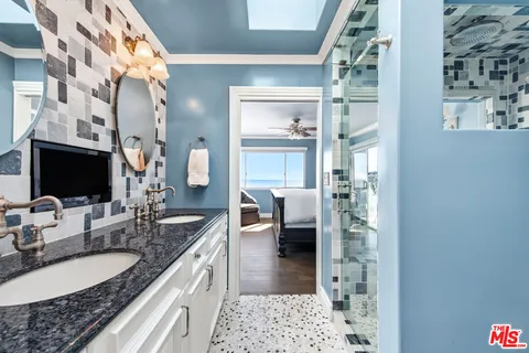 a en suite bathroom with a granite countertop sink and a mirror