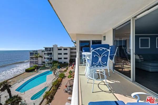 a view of a balcony with chair and ocean view