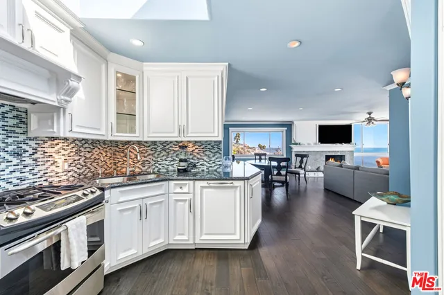 a kitchen with white cabinets and appliances