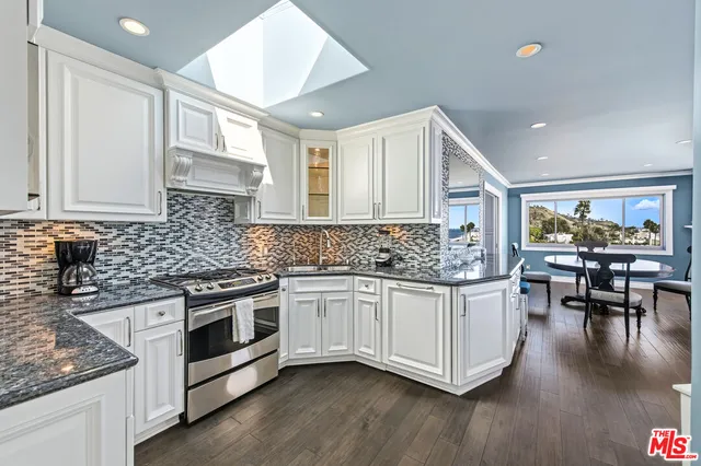 a kitchen with granite countertop white cabinets and white appliances