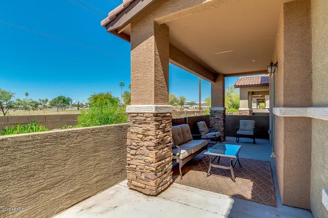 a view of a house with backyard and sitting area