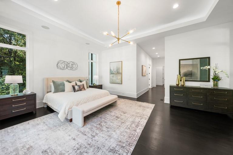 5211 Powers Ferry Road Northwest Sandy Springs, GA 30327 - Photo 46 of 106 a spacious bedroom with a large bed and a flat tv screen on dresser
