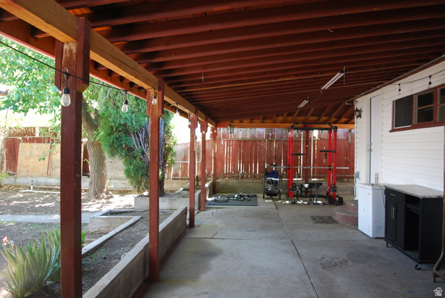 116 North 3rd Street Tooele, UT 84074 - Photo 33 of 45 Expansive covered patio with exposed wood beams, concrete flooring, and perimeter string lighting