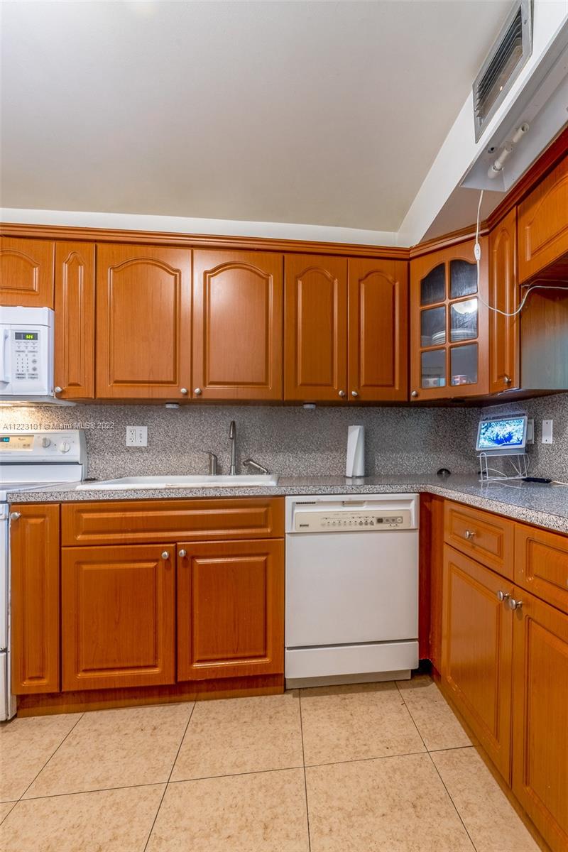 3490 Foxcroft Road, Unit B103 Miramar, FL 33025 - Photo 13 of 37 a kitchen with stainless steel appliances granite countertop a stove sink and cabinets