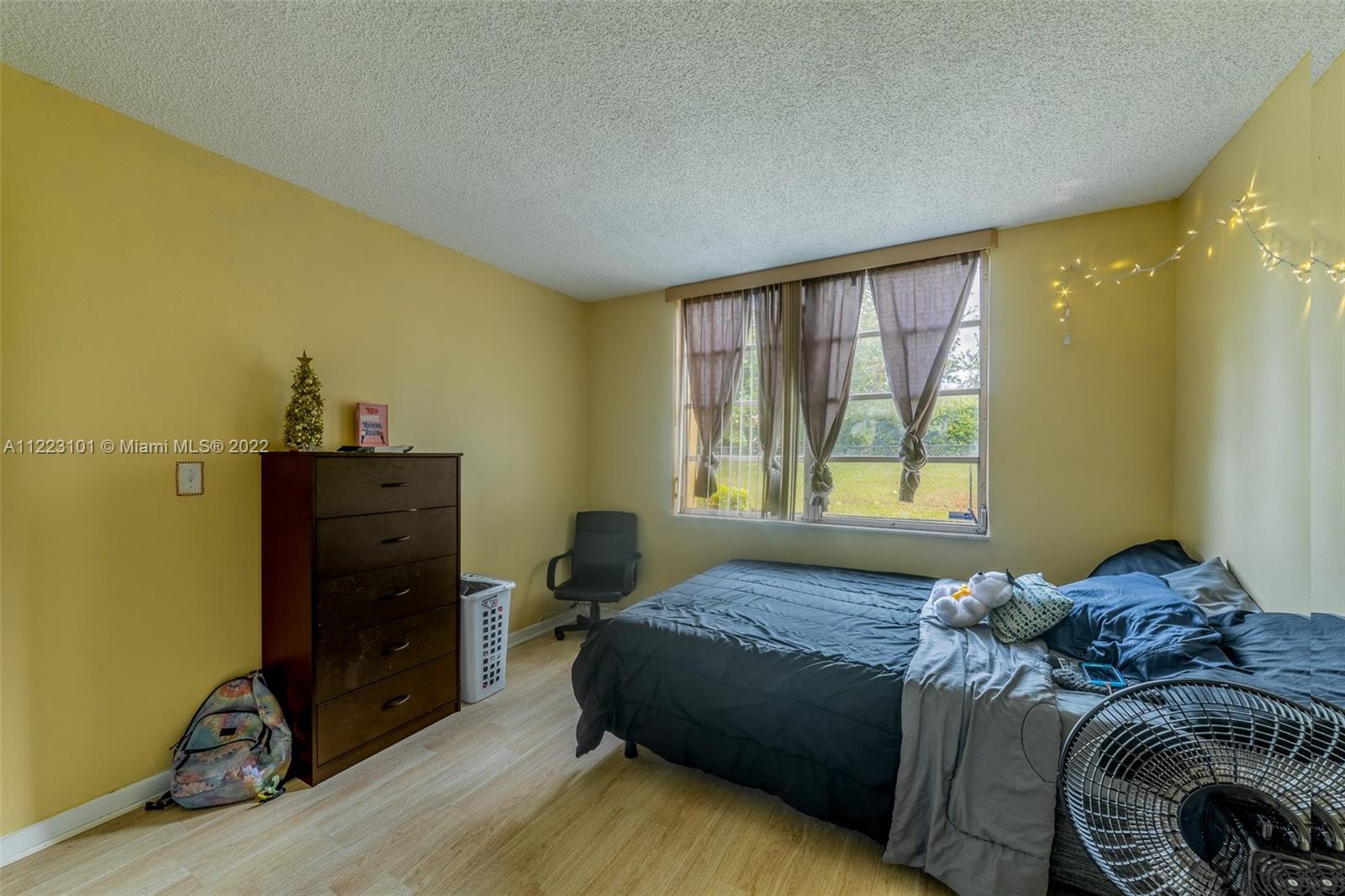 3490 Foxcroft Road, Unit B103 Miramar, FL 33025 - Photo 22 of 37 a bed sitting in a bedroom next to a window