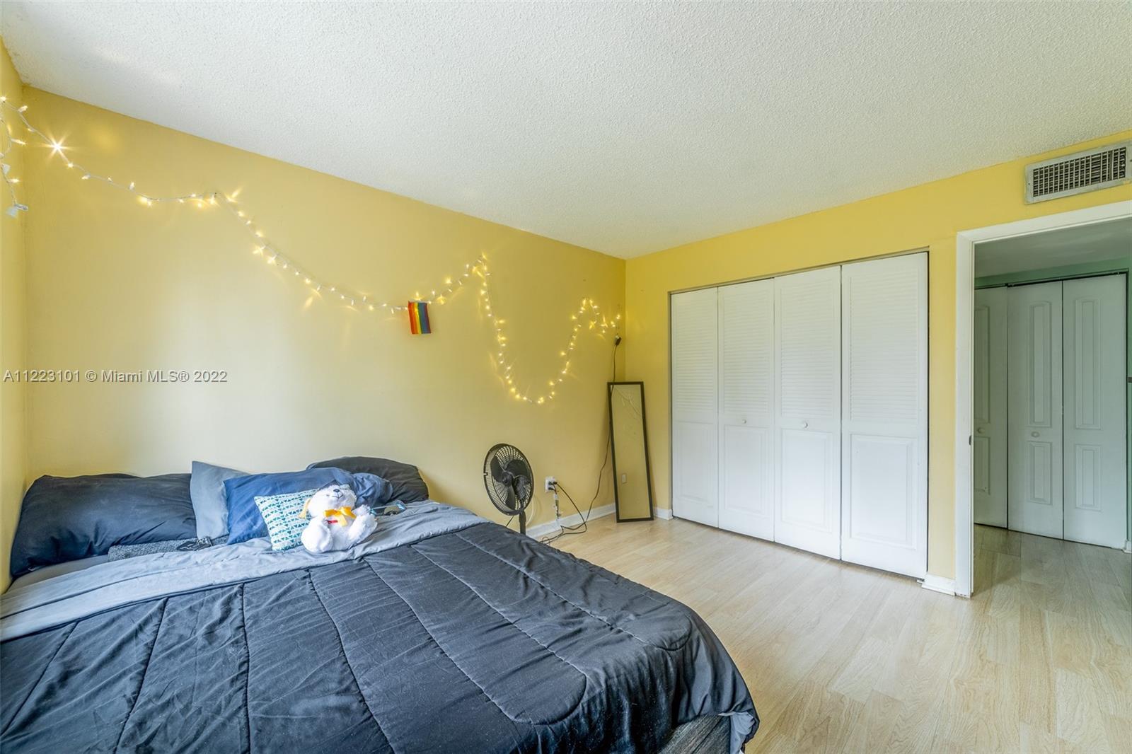 3490 Foxcroft Road, Unit B103 Miramar, FL 33025 - Photo 23 of 37 a spacious bedroom with a bed and wooden floor