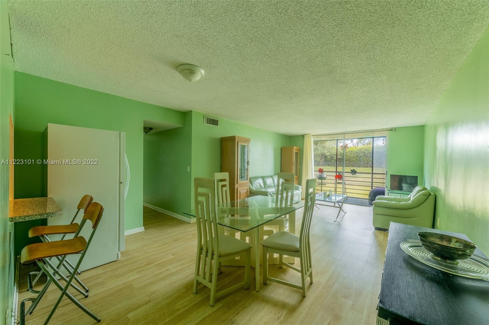 3490 Foxcroft Road, Unit B103 Miramar, FL 33025 - Photo 7 of 37 a room with furniture and a wooden floor