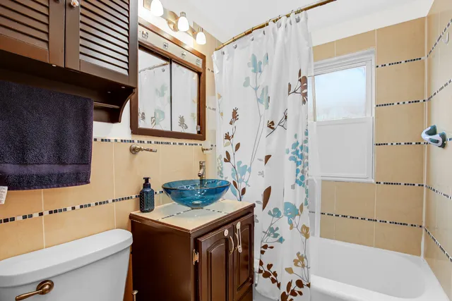 a bathroom with a sink toilet vanity and shower