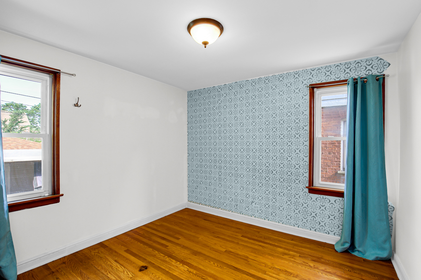 11312 South Avenue H Chicago, IL 60617 - Photo 8 of 21 an empty room with wooden floor and windows