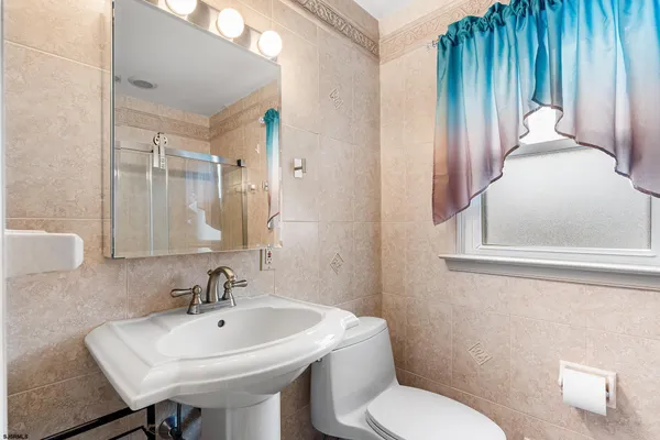 a bathroom with a sink a toilet and a mirror
