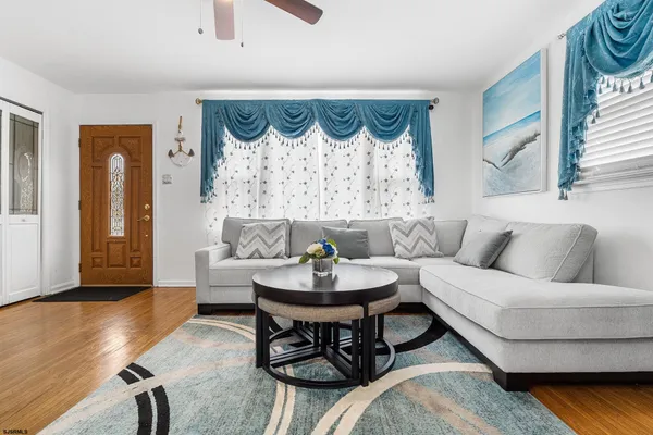 a living room with furniture and a wooden floor