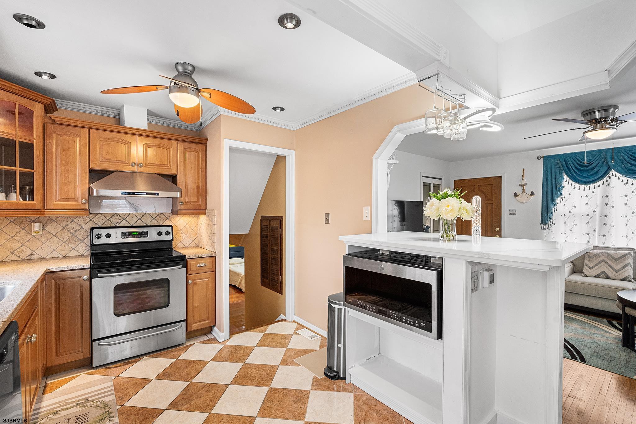 128 Devon Road Somers Point, NJ 08244 - Photo 9 of 40 a kitchen with stainless steel appliances a stove a sink and a refrigerator