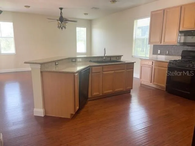 a view of a living room and kitchen with furniture wooden floor