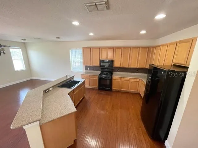an empty room with a window and a chandelier fan