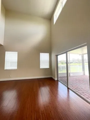 a view of empty room with wooden floor