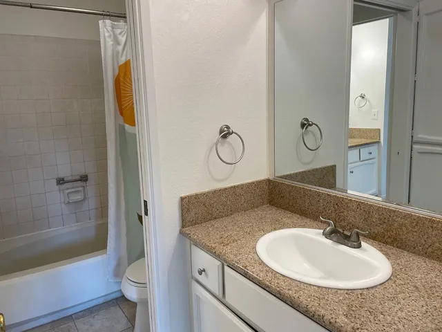 a bathroom with a granite countertop sink toilet and shower