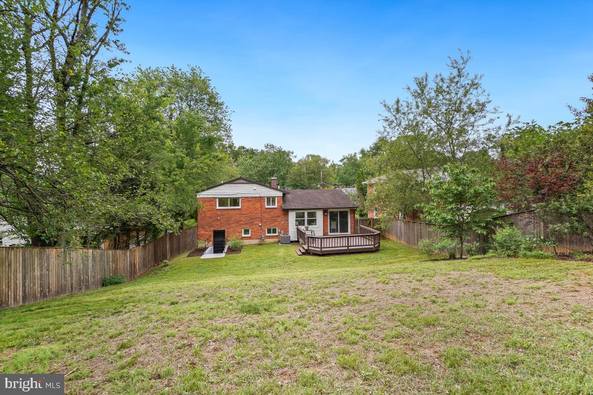 827 Caddington Avenue Silver Spring, MD 20901 - Photo 44 of 45 a house that is sitting in the grass with large trees and plants