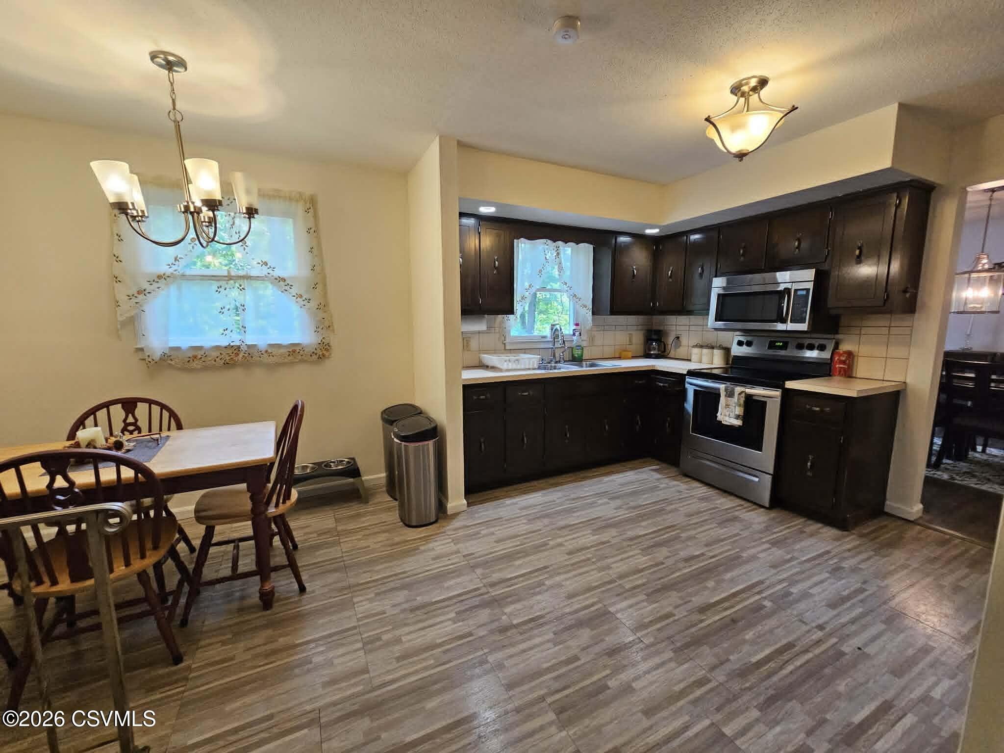 164 Crocus Road Sunbury, PA 17801 - Photo 29 of 38 a kitchen with stainless steel appliances granite countertop wooden floors a stove and a refrigerator
