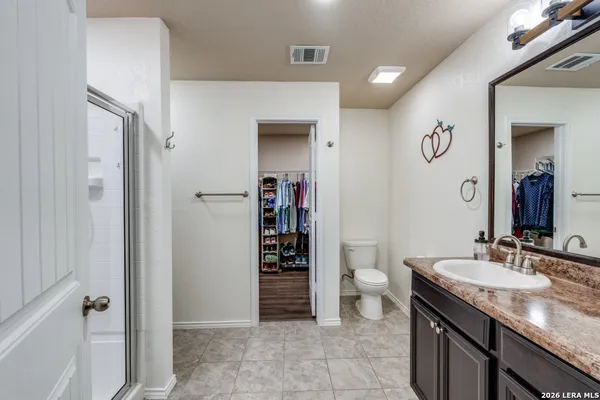 a spacious bathroom with a granite countertop sink and a mirror