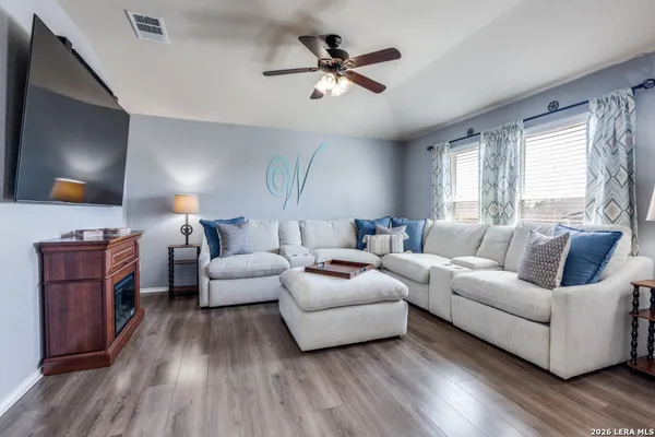 a living room with furniture and a wooden floor