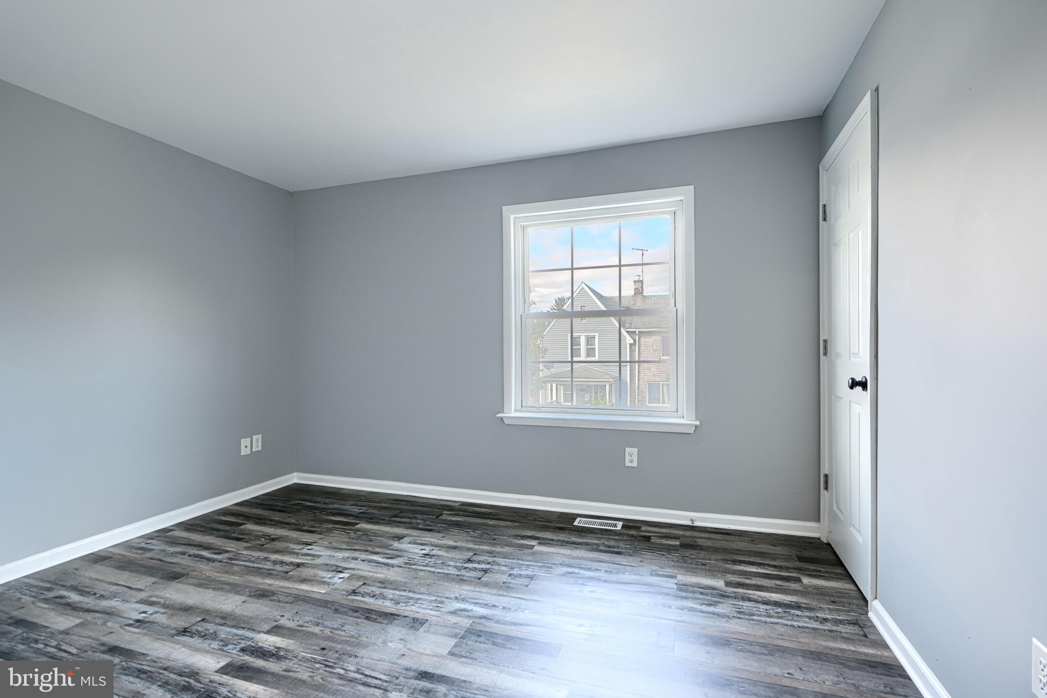 213 Colgate Avenue Baltimore, MD 21222 - Photo 11 of 24 wooden floor in an empty room with a window
