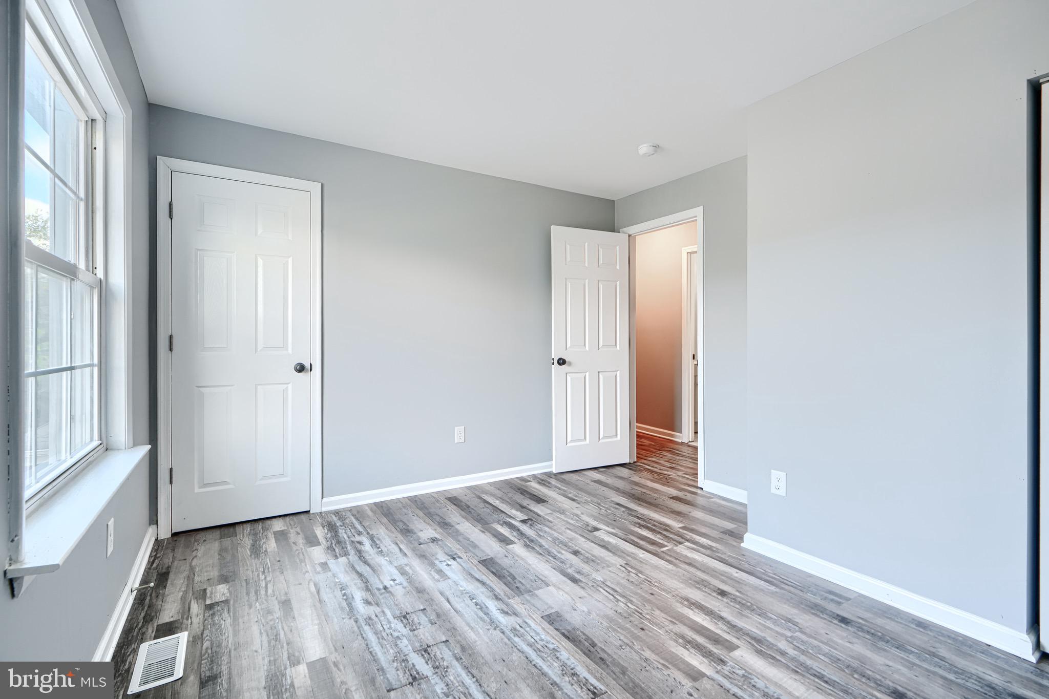 213 Colgate Avenue Baltimore, MD 21222 - Photo 12 of 24 a view of an empty room with wooden floor and a window