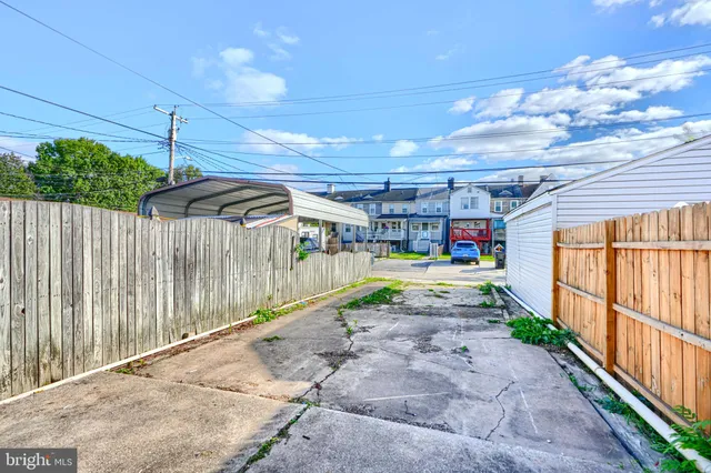 a view of a house with a small yard and wooden fence