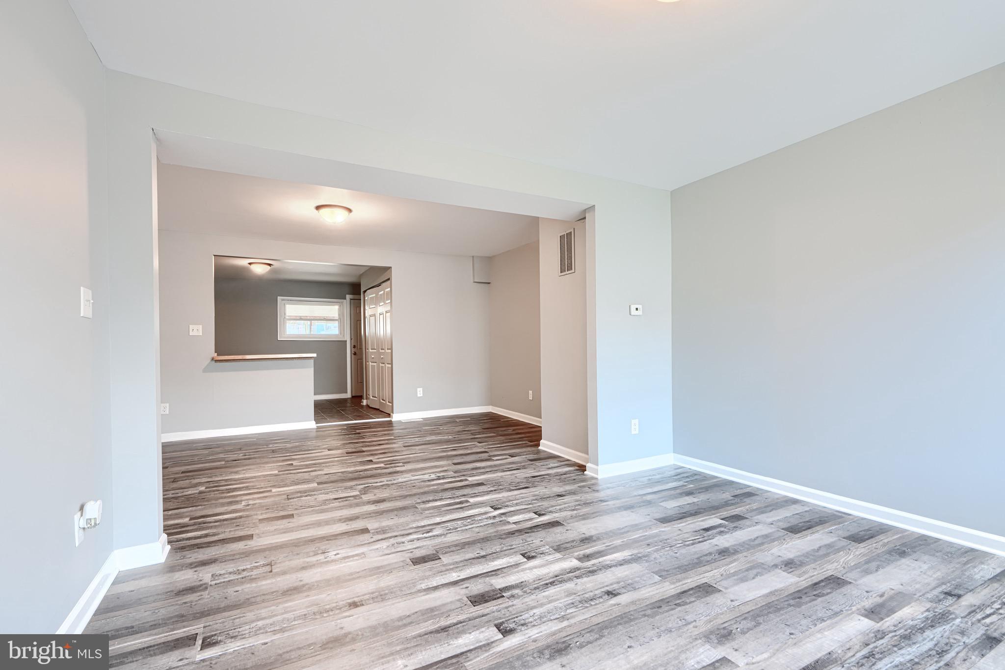 213 Colgate Avenue Baltimore, MD 21222 - Photo 3 of 24 a view of empty room with wooden floor and kitchen