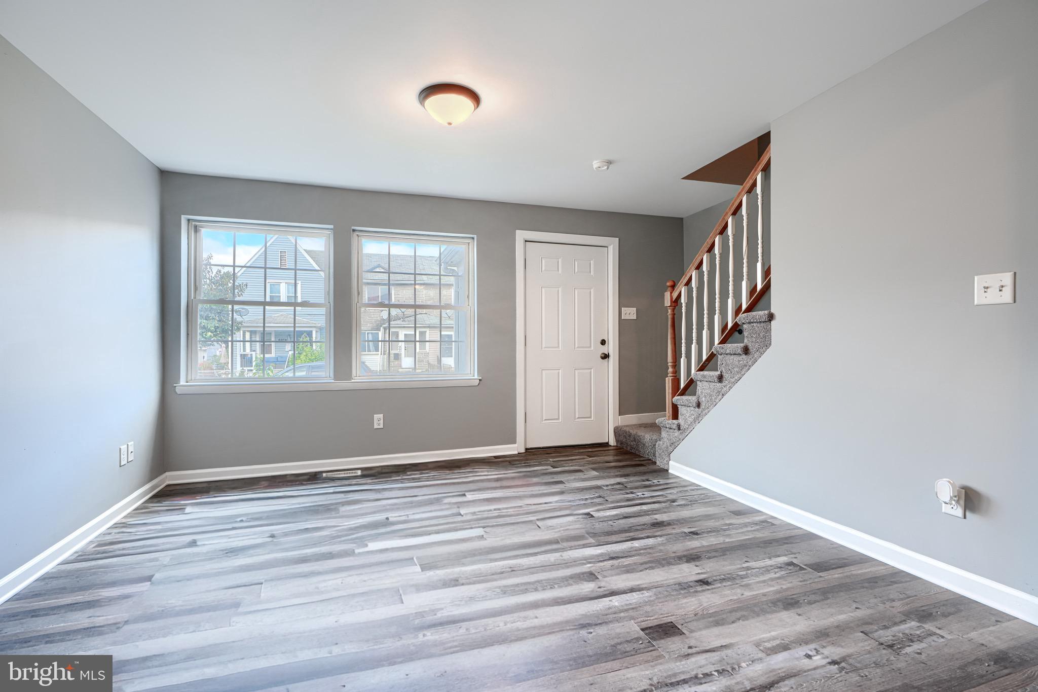 213 Colgate Avenue Baltimore, MD 21222 - Photo 5 of 24 a view of an empty room with wooden floor and a window