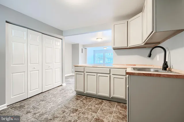 a kitchen with stainless steel appliances granite countertop a sink a stove and white cabinets with wooden floor