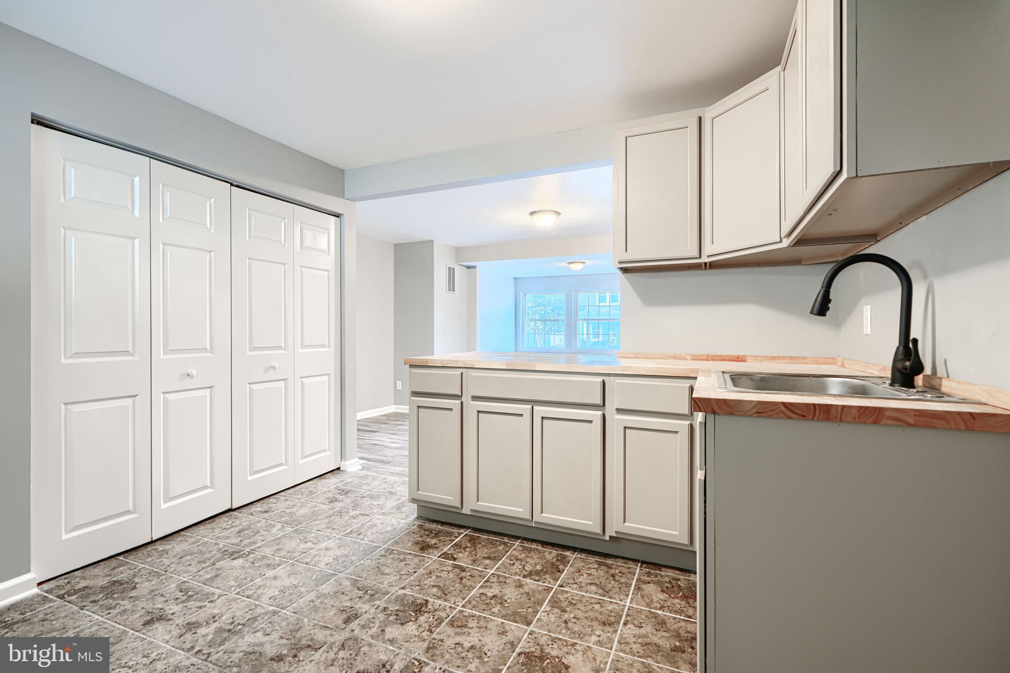 213 Colgate Avenue Baltimore, MD 21222 - Photo 9 of 24 a kitchen with stainless steel appliances granite countertop a sink a stove and white cabinets with wooden floor