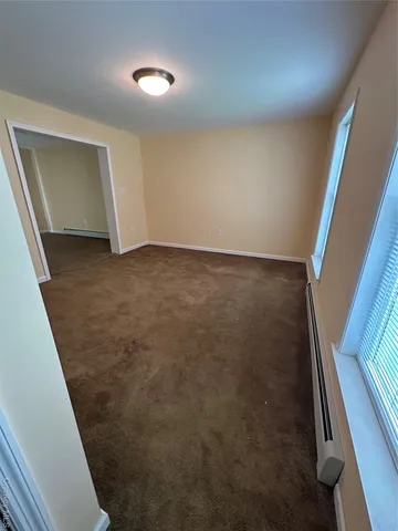 a view of an empty room with wooden floor and stairs