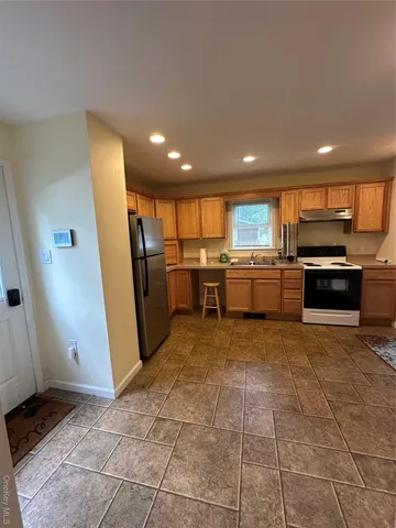 a open kitchen with stainless steel appliances granite countertop a refrigerator and a stove top oven